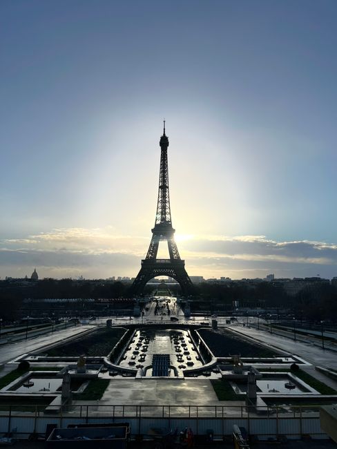 A breathtaking view of the Eiffel Tower at sunrise, casting a silhouette over Paris.