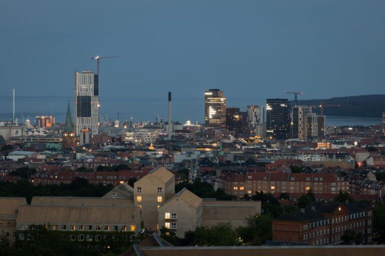 Skyline of Aarhus at twilight, showcasing modern architecture and waterfront views.