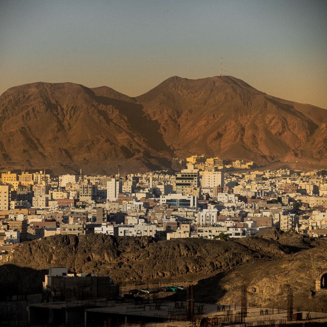 A beautiful view of Madinah, Saudi Arabia, with mountains and cityscape at sunset.