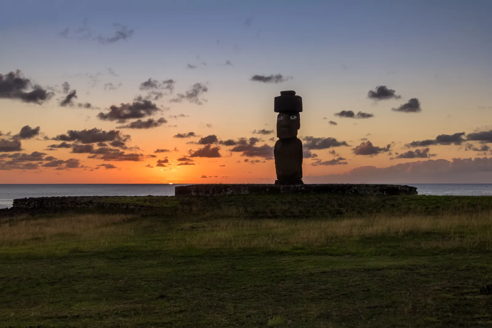 A moai with its red topknot at Ahu Tahai at sunset, Hanga Roa, Easter Island