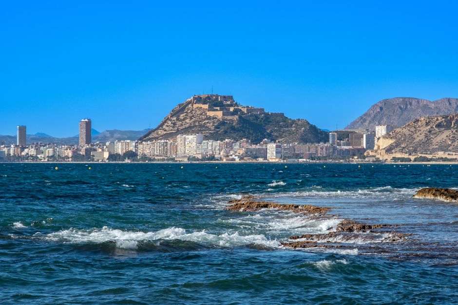 Picturesque view of Alicante's coastline with the iconic Santa Bárbara Castle on a sunny day.