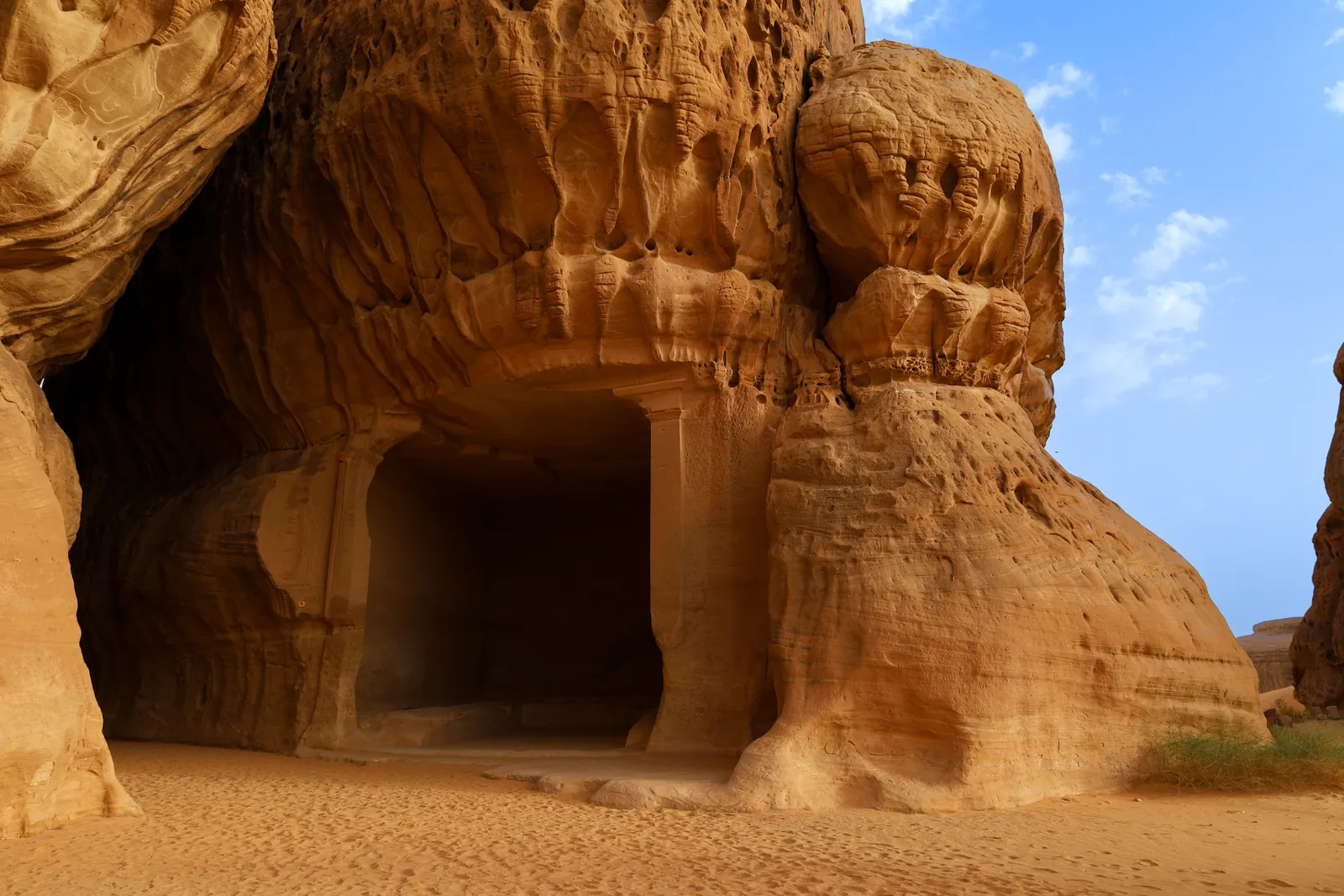 A Nabataean tomb carved into the golden sandstone at Hegra, AlUla, Saudi Arabia