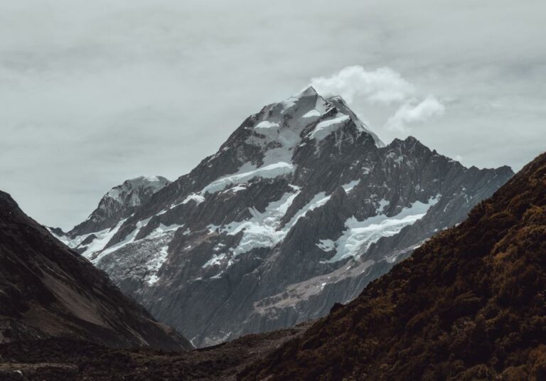 Breathtaking view of Mount Cook's snow-capped summit surrounded by dramatic landscapes in Canterbury, New Zealand.