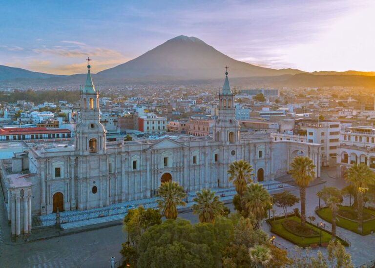 Drone shot of Arequipa's cathedral with El Misti volcano in the background at sunset.