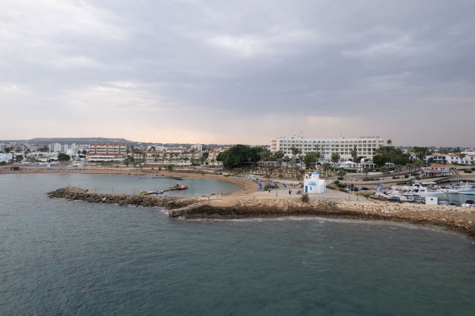 A serene aerial view of Pernera coastline, showcasing the harbor and iconic white church.