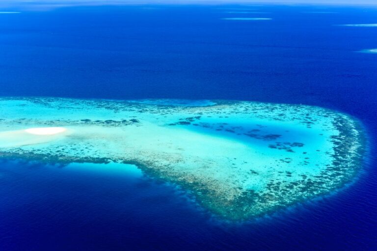 Stunning aerial view of vibrant coral reefs and turquoise waters in Eydhafushi, Maldives.