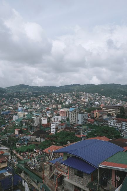 Explore the vibrant urban landscape of Baguio City under a cloudy sky, showcasing its unique architecture.