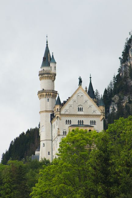 Vertical view of Neuschwanstein Castle amidst lush greenery in Bavaria, Germany.