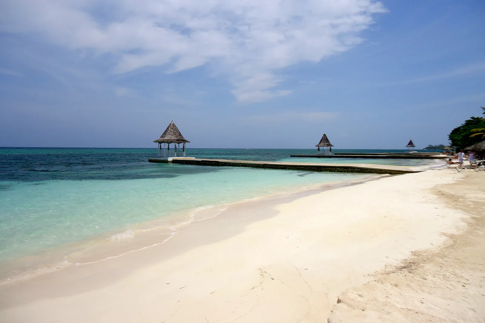 A white-sand beach and pier with a gazebo on the Caribbean Sea, Jamaica