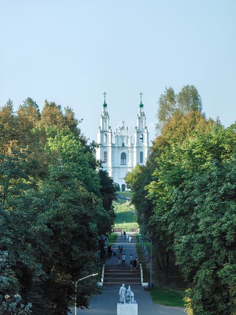Stunning cathedral view framed by lush trees on a sunny day.
