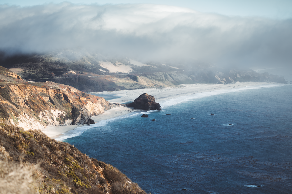 Breathtaking coastal landscape of Big Sur with clouds and ocean waves.