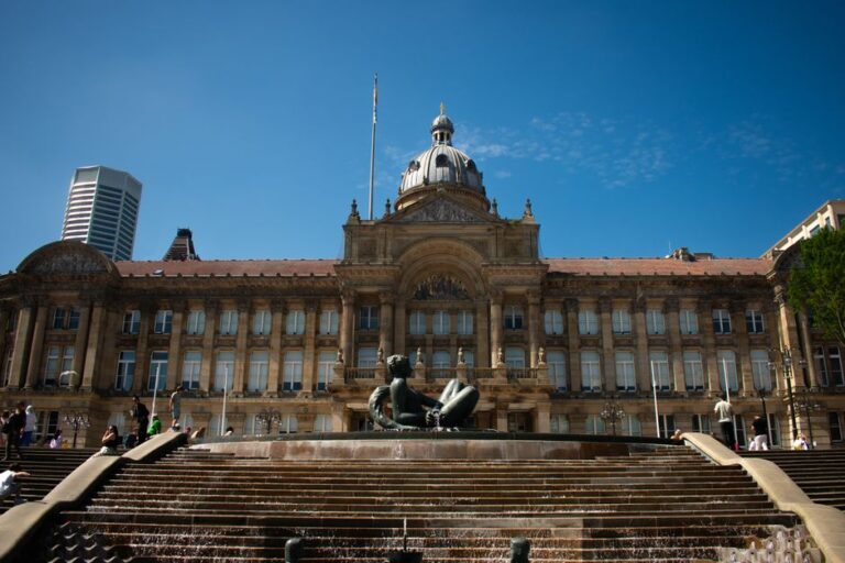 Stunning view of Birmingham Council House with clear sky and fountain in the foreground, capturing architectural elegance.