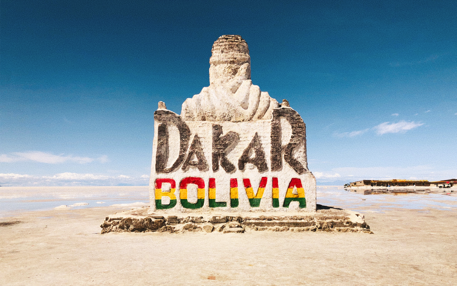 Stone monument at Salar de Uyuni celebrating the Dakar Rally in Bolivia's remote desert landscape.