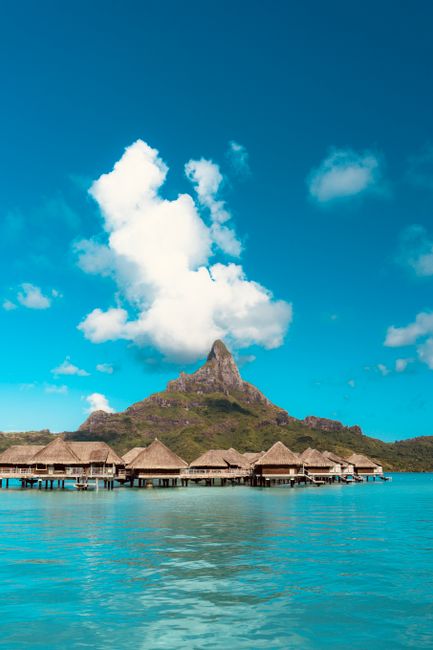 A breathtaking view of Bora-Bora's lagoon with overwater bungalows and mountain backdrop.