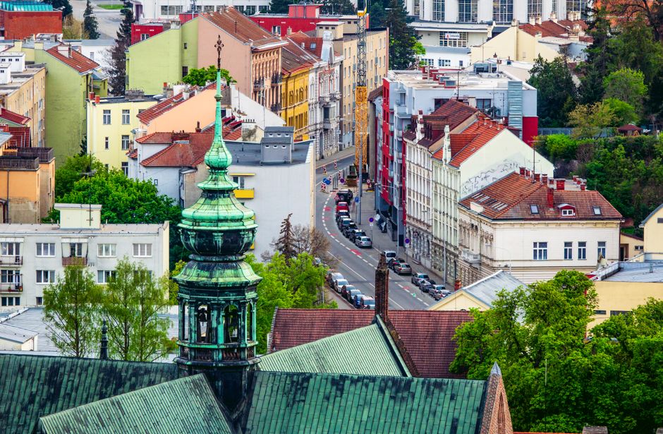 Aerial view of the colorful cityscape of Brno, highlighting its green tower and gothic architecture.