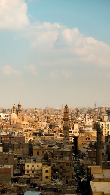 Discover Cairo's historic skyline, featuring iconic minarets and ancient architecture under a bright sky.