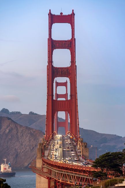 Iconic view of the Golden Gate Bridge at dusk with flowing traffic, showcasing its grandeur.