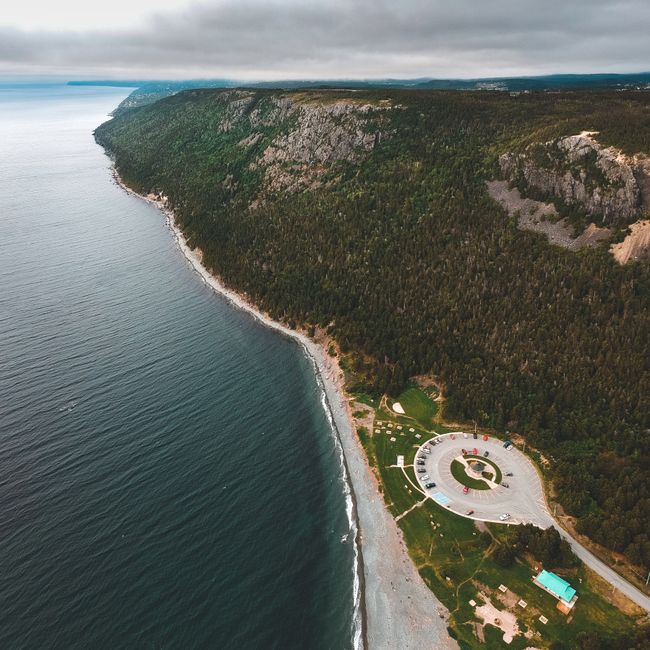 Breathtaking aerial shot of coastal cliffs and ocean under cloudy skies, promising exploration and adventure.