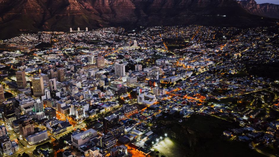 A stunning aerial view of Cape Town city lights at night against Table Mountain.