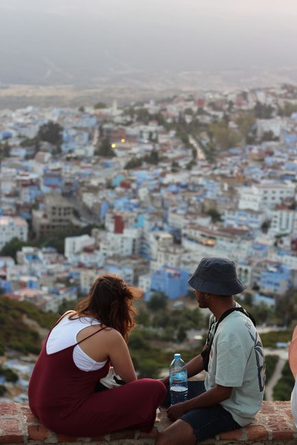 Young couple taking in the panoramic view of the Blue City, Chefchaouen, Morocco.