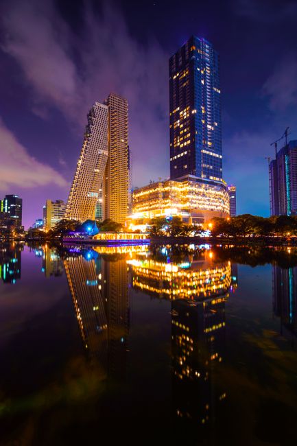 Stunning nighttime cityscape of Colombo's skyline with reflections in water.