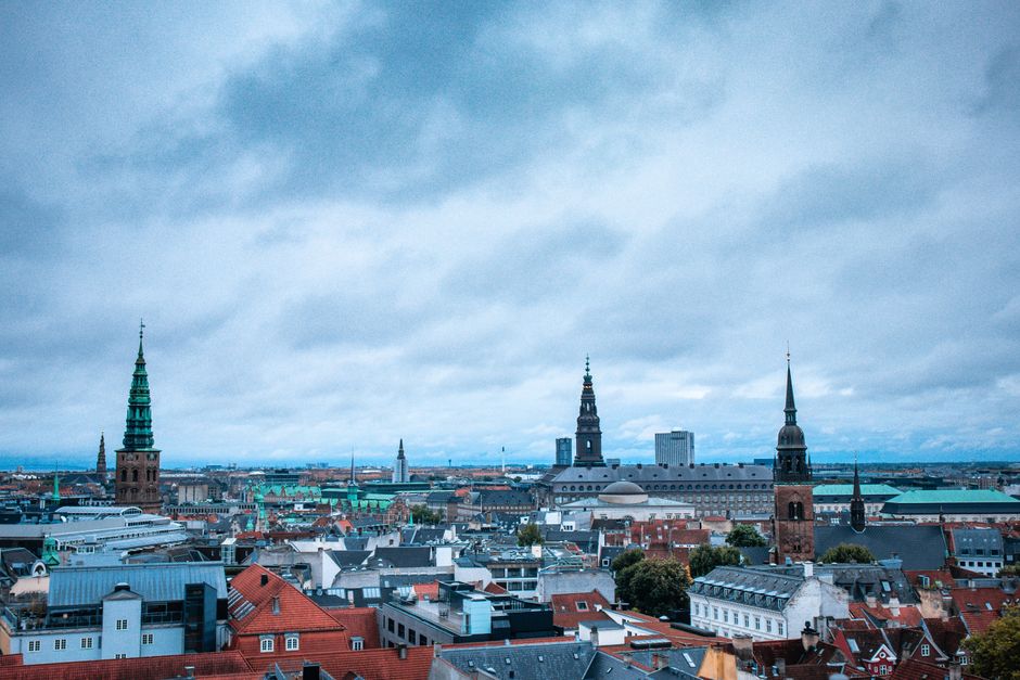 Wide-angle view of Copenhagen's historic architecture and skyline under overcast skies. Ideal for urban exploration themes.