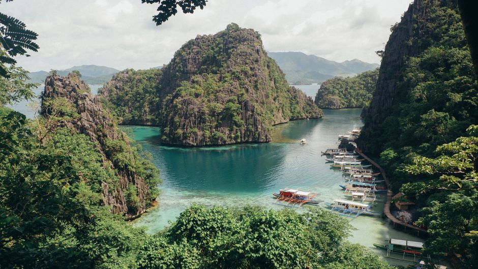 Explore Coron Bay, a tropical paradise with clear waters and limestone cliffs in the Philippines.