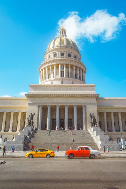 Iconic National Capitol in Havana with vibrant classic cars and tourists