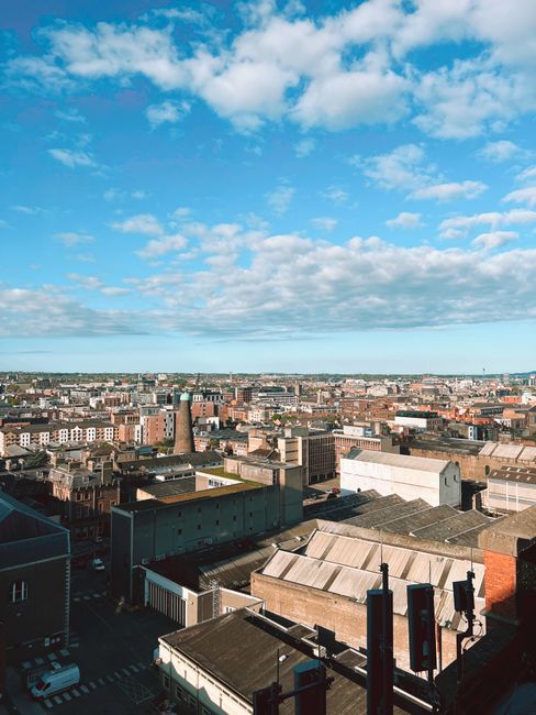 Urban landscape of Dublin city under a clear blue sky, captured from above.