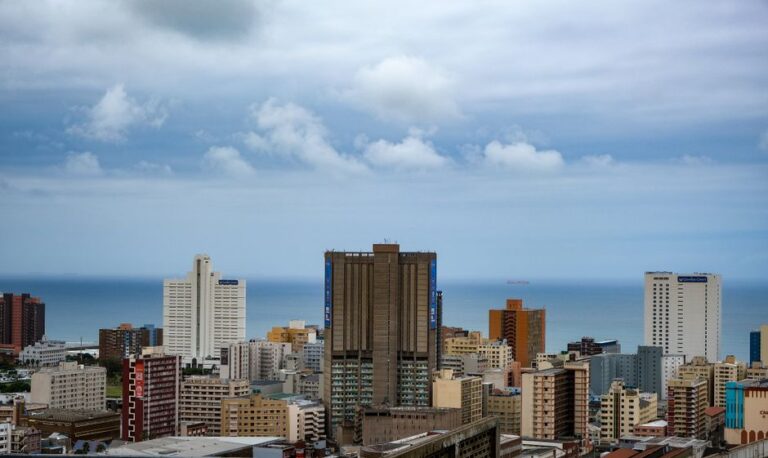 Aerial view of Durban's modern cityscape against the Indian Ocean with high-rise buildings.