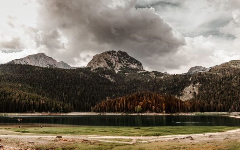 Serene mountain landscape of Black Lake and forests in Montenegro under dramatic clouds.