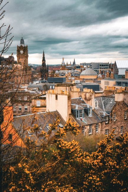 A scenic view of Edinburgh's historic skyline with iconic architecture under a dramatic sky.