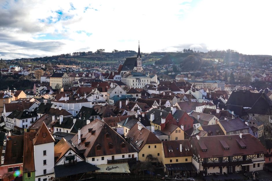 Aerial view of Český Krumlov's charming old town with historic rooftops and church spire.