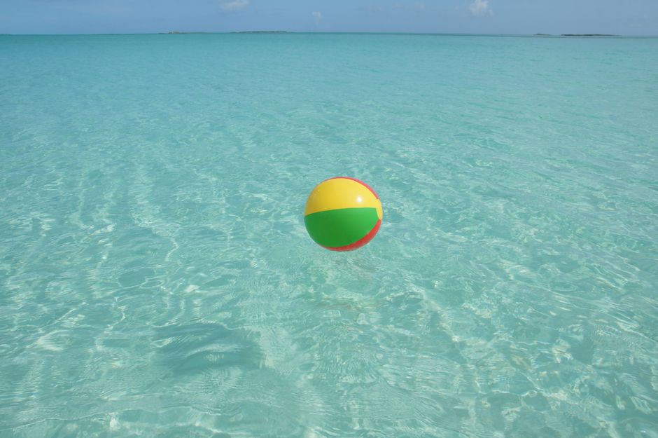 Vibrant beach ball floating on turquoise waters in George Town, Bahamas. Perfect for vacation vibes.