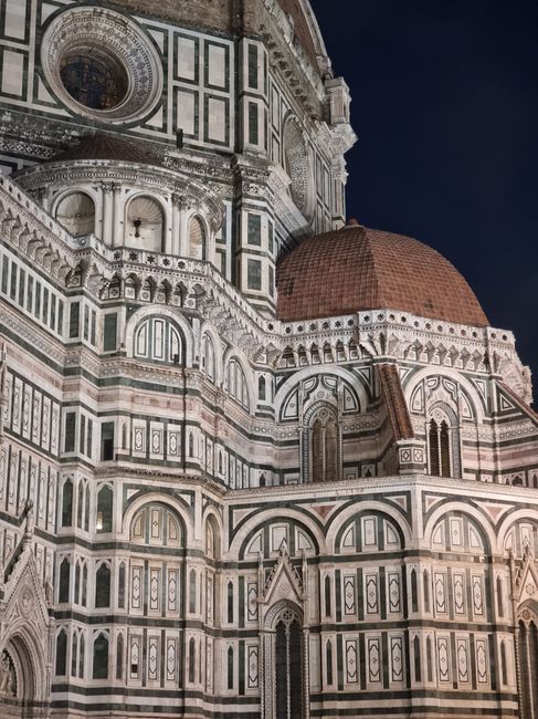 Detailed view of Florence Cathedral's facade with its iconic architectural features at night.