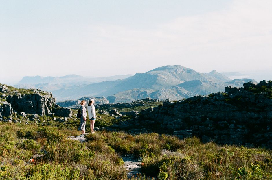 Two women enjoy a scenic hike in the breathtaking landscape of Cape Town, South Africa.