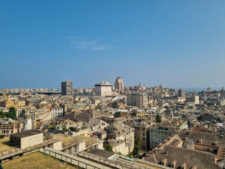 A stunning aerial view of Genoa's skyline highlighting the city's architecture under a clear blue sky.