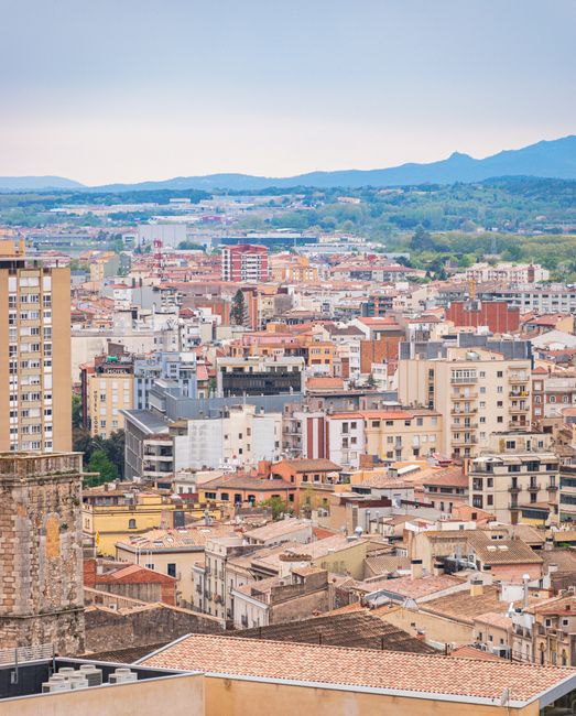 A stunning aerial view of Girona, showcasing its vibrant urban architecture against a scenic backdrop.