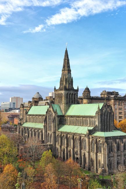 Stunning aerial view of historic Glasgow Cathedral with a beautiful blue sky backdrop.