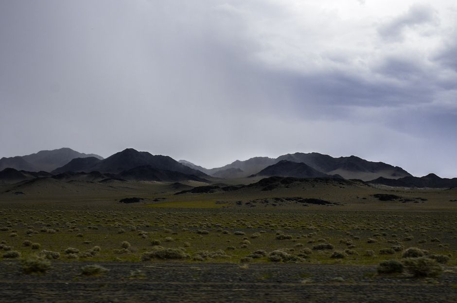 Scenic view of Mongolian mountains with cloudy sky, capturing the vast wilderness.