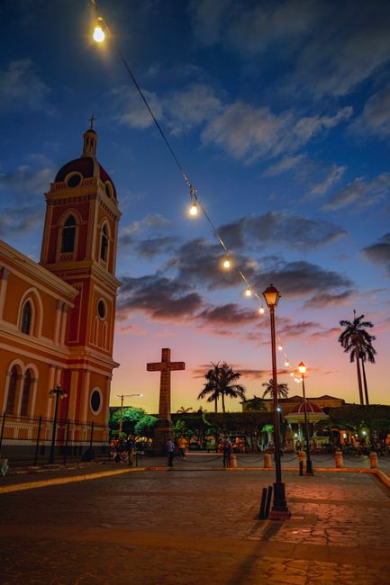 Stunning view of Granada Cathedral at dusk with vibrant sunset sky and city lights.