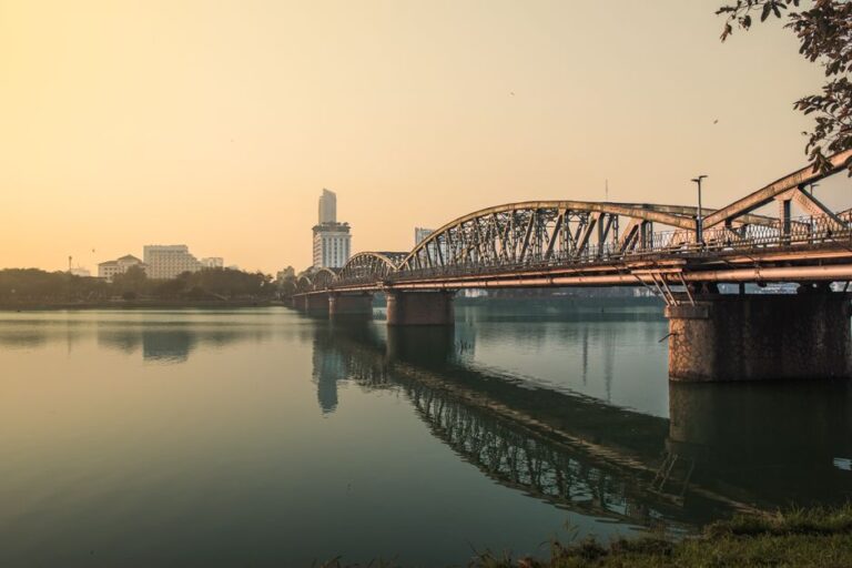 Serene sunset over Trường Tiền Bridge reflecting on the Perfume River in Hue, Vietnam.