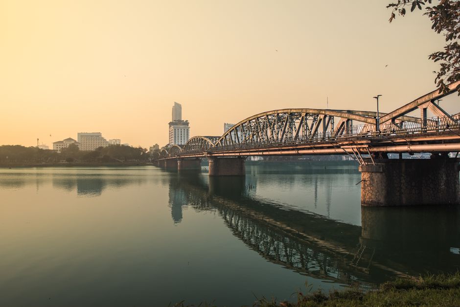 Serene sunset over Trường Tiền Bridge reflecting on the Perfume River in Hue, Vietnam.