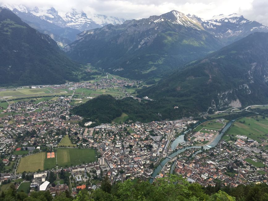 Stunning aerial view of Interlaken surrounded by the magnificent Swiss Alps under cloudy skies.