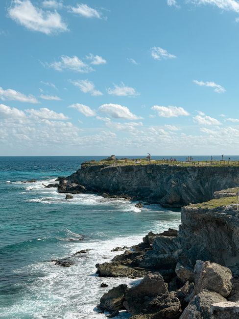 Breathtaking view of rocky cliffs and ocean waves on Isla Mujeres in Mexico.