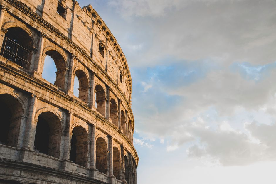 Breathtaking image capturing the historic Roman Colosseum against a cloudy sky at sunset.