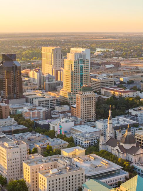 Aerial view of Sacramento's skyline with the iconic Cathedral of the Blessed Sacrament at sunset.