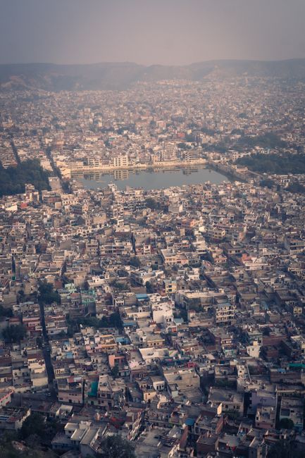 Stunning aerial view of Jaipur cityscape featuring dense urban architecture and a central lake.