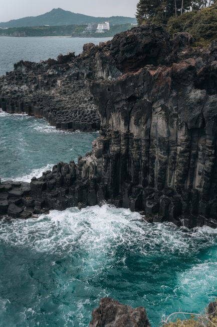 Dramatic cliffs and vibrant ocean waves at Jeju Island's stunning shoreline.