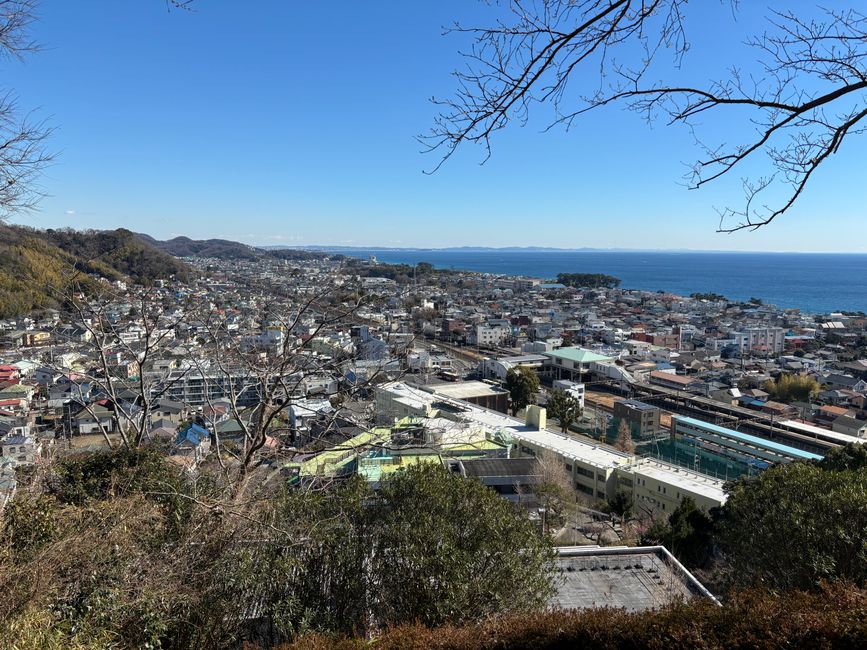 A stunning aerial view of Kamakura cityscape by the sea with clear skies.